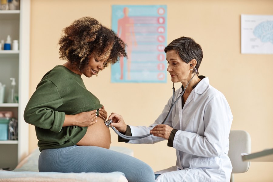 Physician checking a pregnant patient with a stethoscope