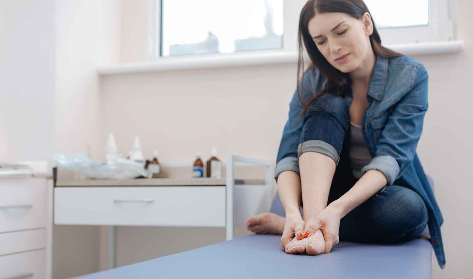 Patient holding foot in discomfort from joint pain