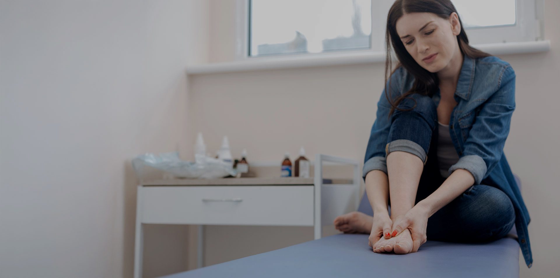 Patient holding foot in discomfort from joint pain