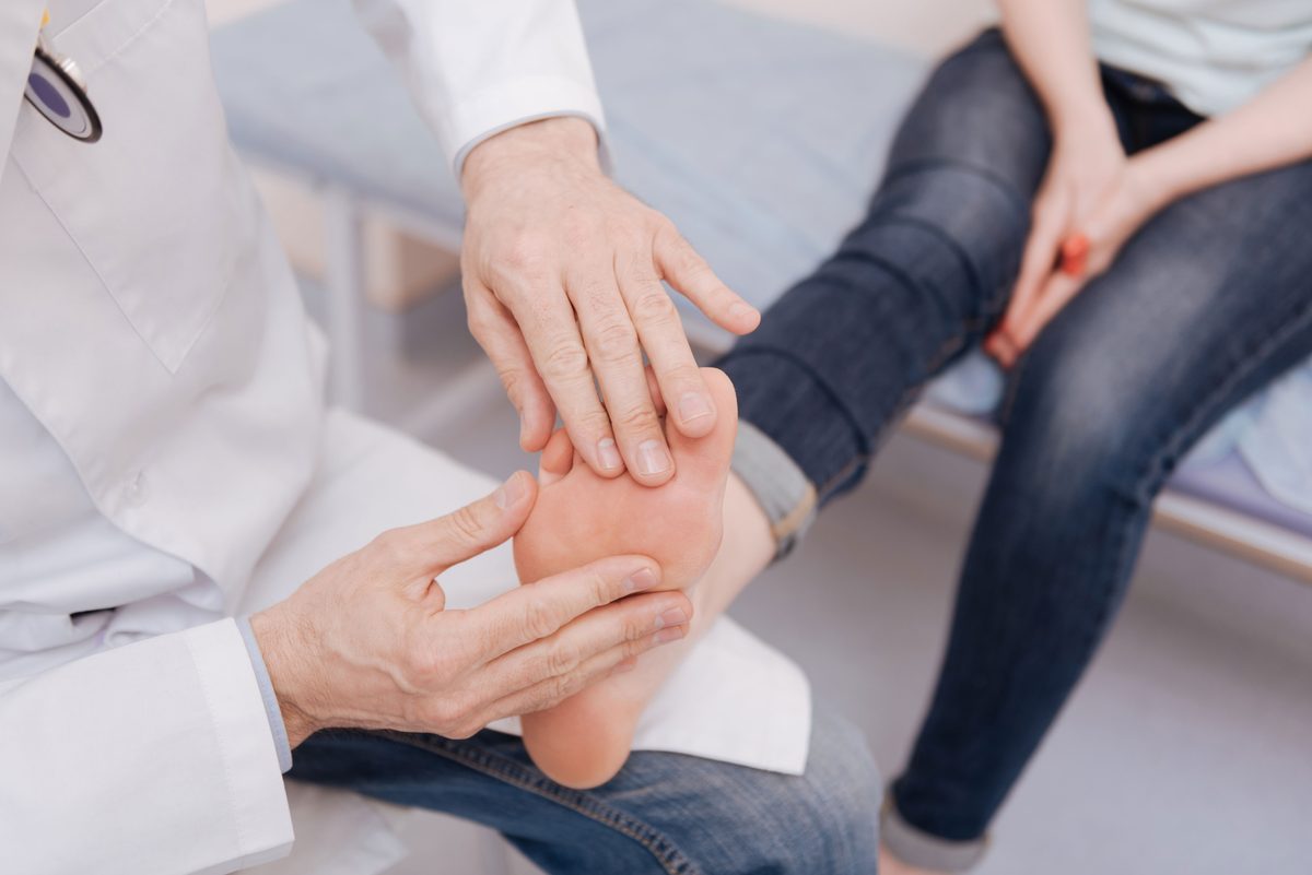 Physician examining a patient's foot for joint pain